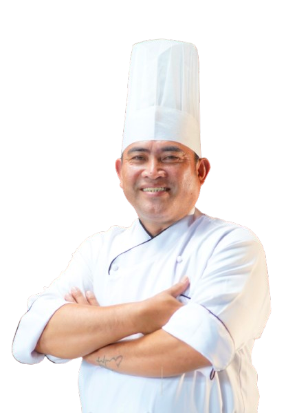 Chef in white uniform and hat, arms crossed, smiling.